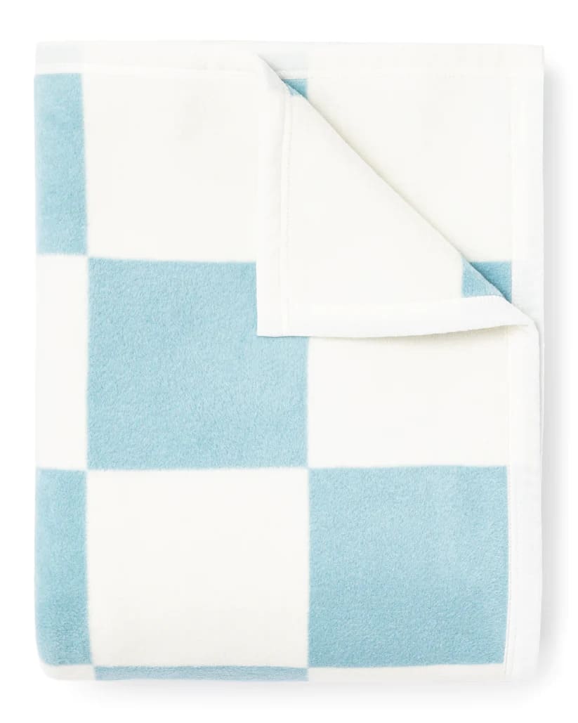 The Westerly Co Boardwalk blanket gives casual coastal vibes. The square checker pattern in white and blue, transport you to the sunlit boardwalk, where the sound of the waves and the ocean breeze await.