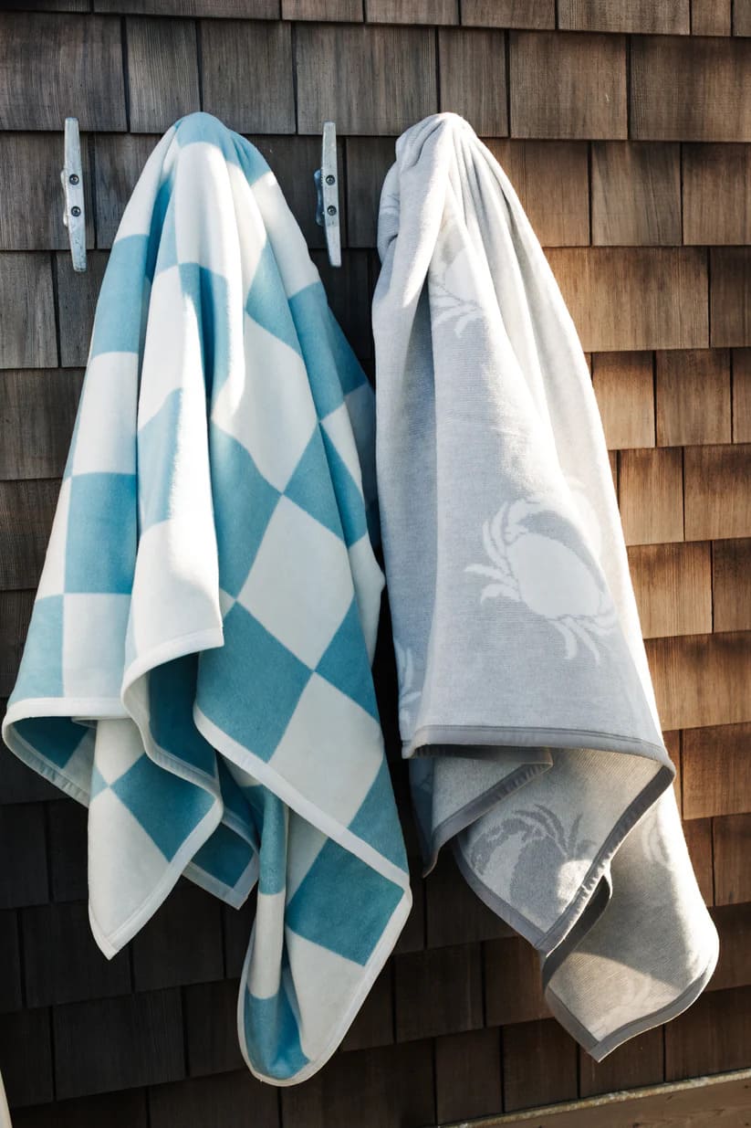 The Westerly Co Boardwalk blanket gives casual coastal vibes. The square checker pattern in white and blue, transport you to the sunlit boardwalk, where the sound of the waves and the ocean breeze await. It's preppy, it's modern and exudes coastal comfort.